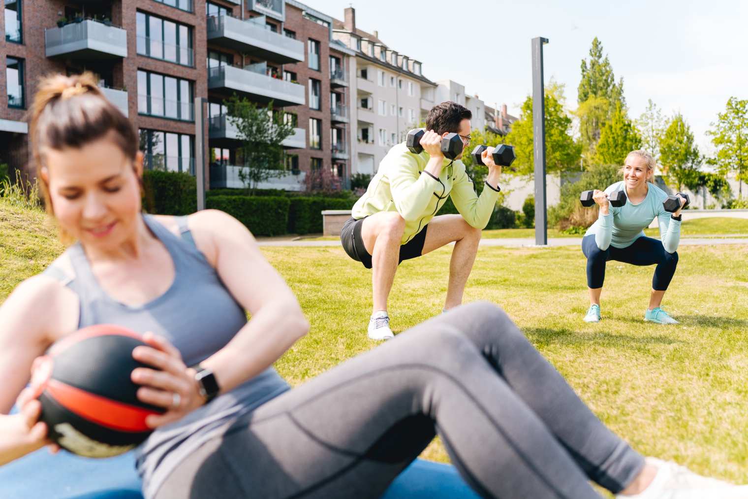 Gemeinsames Training im Fitnesskurs: Gruppe macht Kniebeugen – soziale Unterstützung motiviert beim Dranbleiben