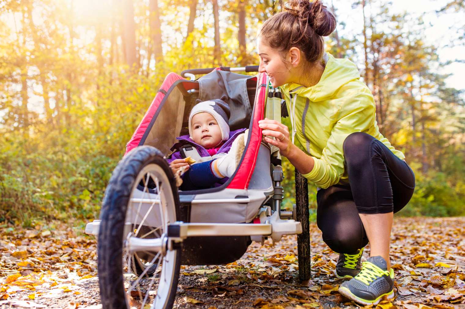 Sport nach der Geburt trotz wenig Zeit: Mama joggt mit Baby im Kinderwagen an der frischen Luft